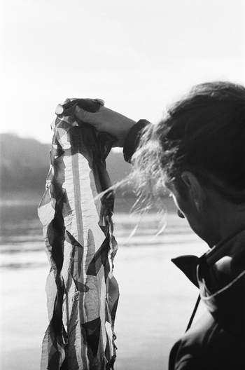 Hugo Roellinger at the water's edge, holding a piece of cloth.